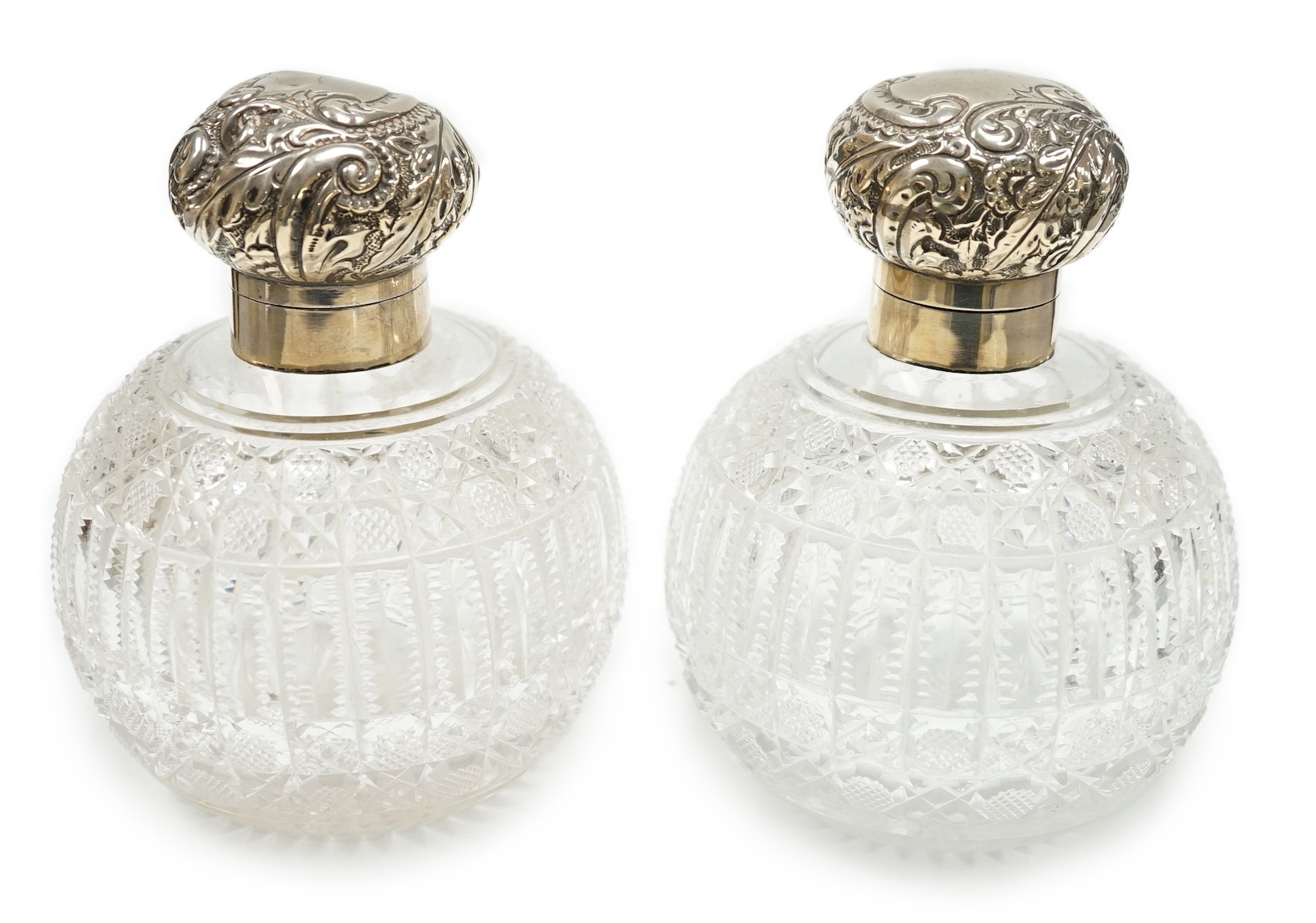 A pair of late Victorian silver mounted cut glass globular scent bottles (a.f.), Haseler Brothers, Birmingham, 1894/5, height 14.9cm.